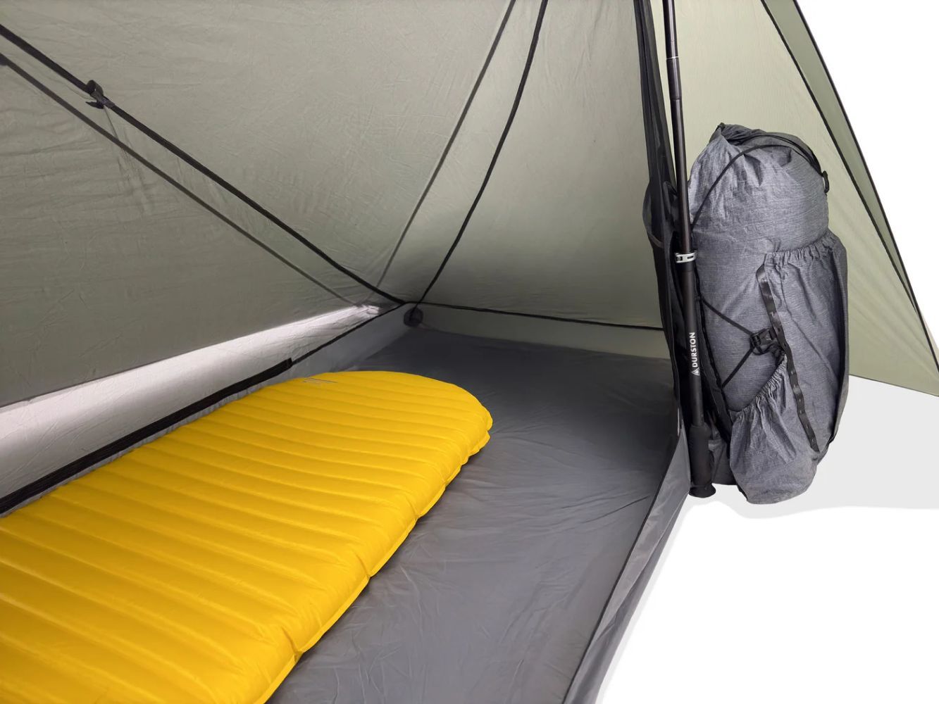 Sleeping pad and backpack arranged inside a one-person backpacking tent