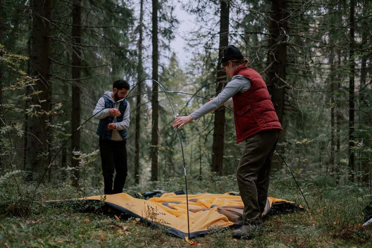 Freestanding tent pole structure being set up at a campsite