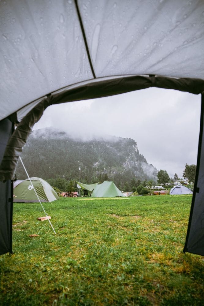Backpacking tent placed and tensioned at a protected rain-and-wind campsite