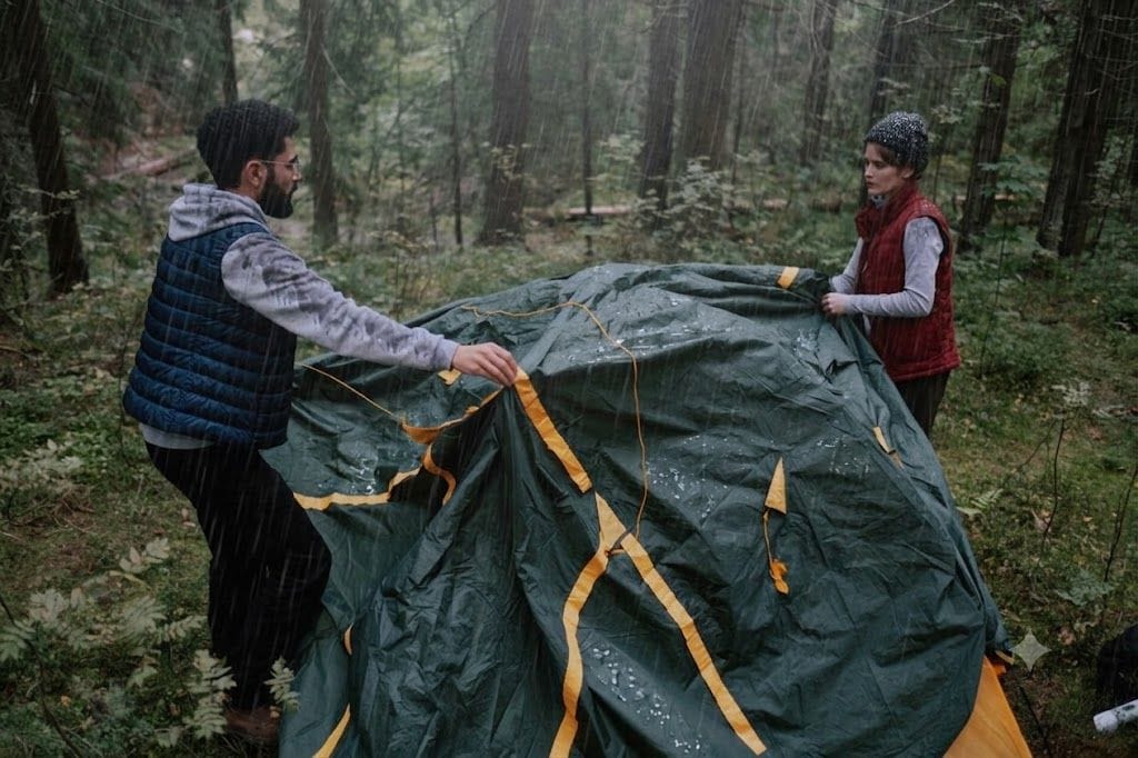 Backpacker wiping and airing a tent after overnight condensation
