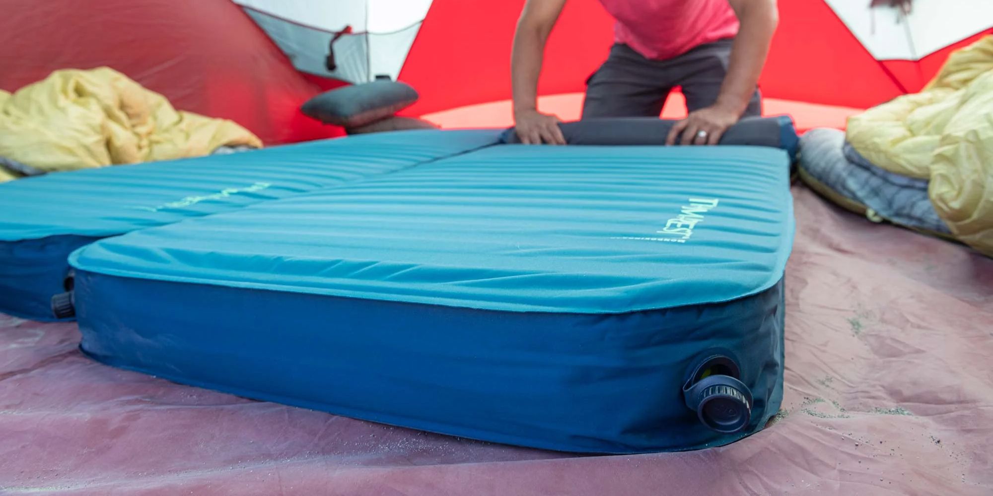 Backpacking sleeping pad and sleeping bag arranged inside a tent